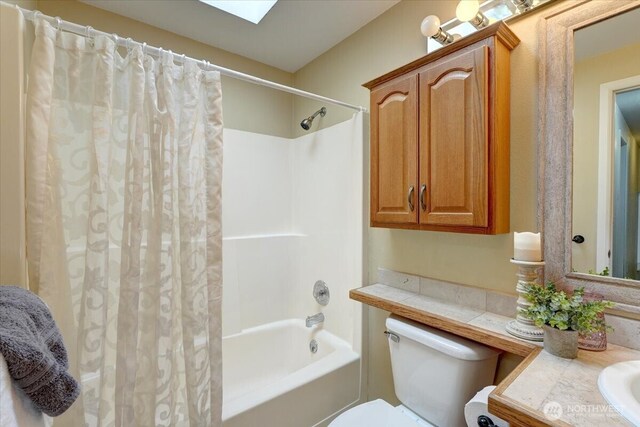 bathroom featuring toilet, shower / bath combo with shower curtain, and vanity