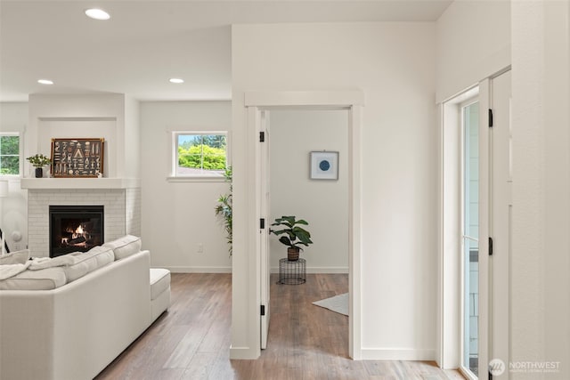 living area featuring recessed lighting, a fireplace, and light wood-type flooring