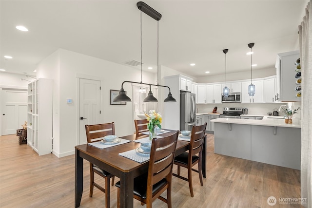 dining room with recessed lighting, visible vents, and light wood finished floors