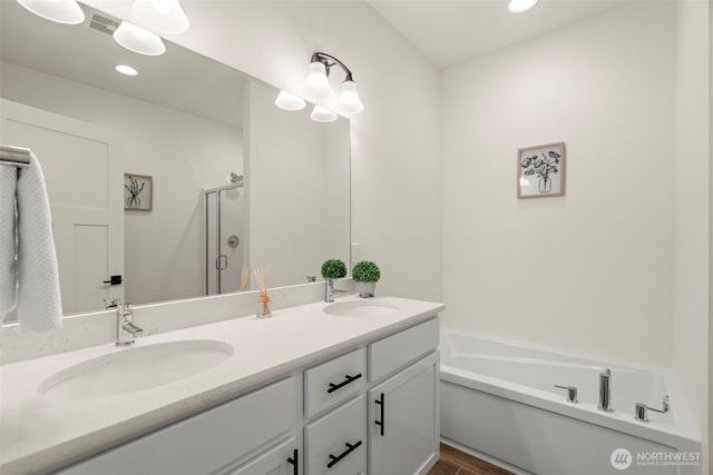 full bathroom with double vanity, a sink, a garden tub, and a stall shower