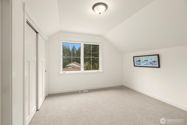 bonus room with baseboards, visible vents, light carpet, and lofted ceiling