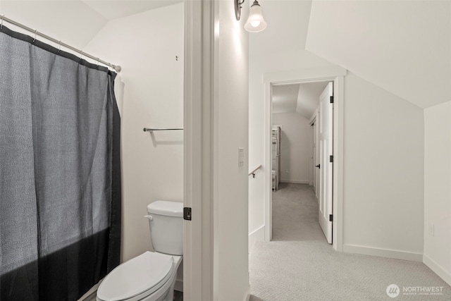 full bath with toilet, baseboards, and lofted ceiling