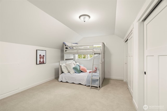 bedroom featuring baseboards, light carpet, and vaulted ceiling