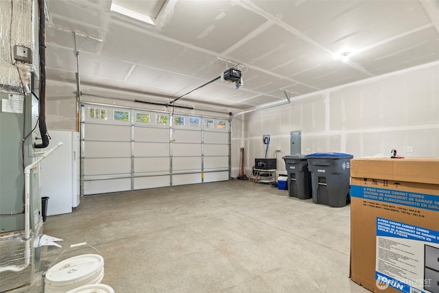 garage featuring a garage door opener, heating unit, and electric panel