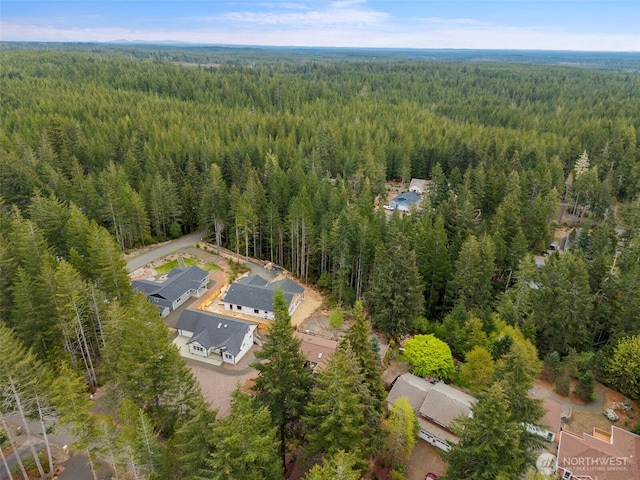 drone / aerial view featuring a wooded view