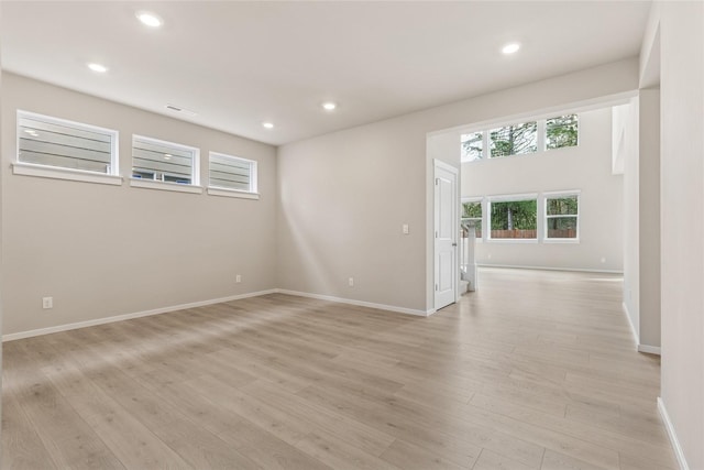 spare room with baseboards, recessed lighting, light wood-style flooring, and visible vents
