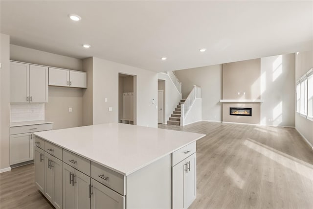 kitchen featuring light wood-type flooring, light countertops, a kitchen island, and recessed lighting