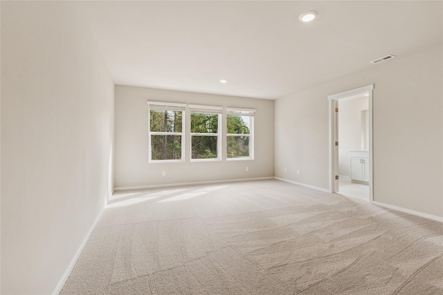 spare room with visible vents, recessed lighting, baseboards, and light colored carpet