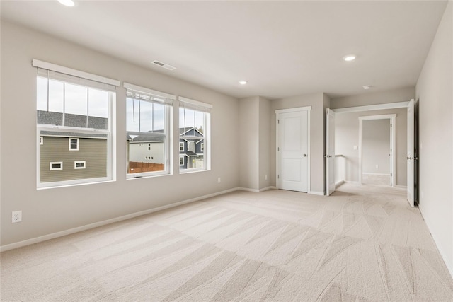 unfurnished bedroom featuring visible vents, recessed lighting, baseboards, and light carpet