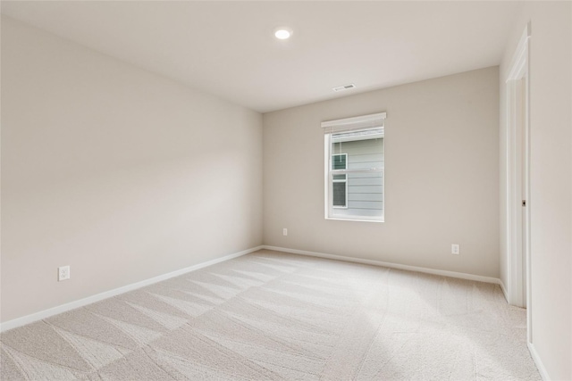 empty room with recessed lighting, baseboards, light colored carpet, and visible vents