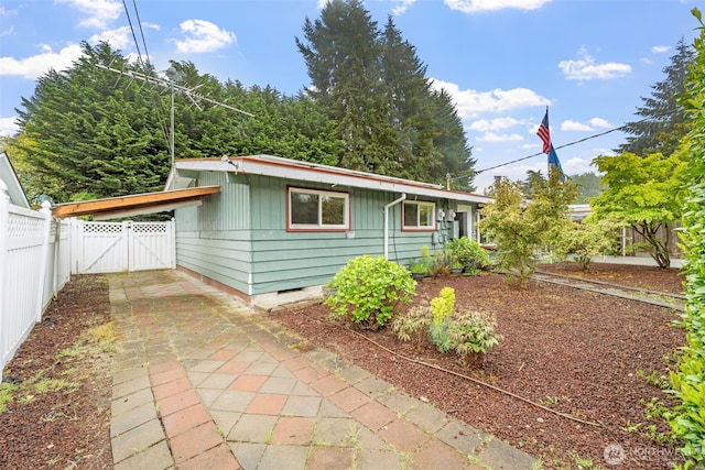 view of home's exterior featuring a gate, fence, and crawl space