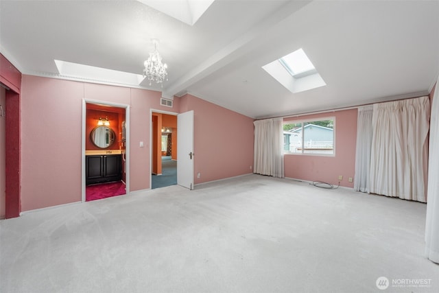 interior space featuring an inviting chandelier, carpet floors, lofted ceiling with skylight, and visible vents