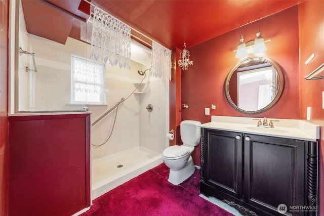 bathroom featuring vanity, toilet, and a shower