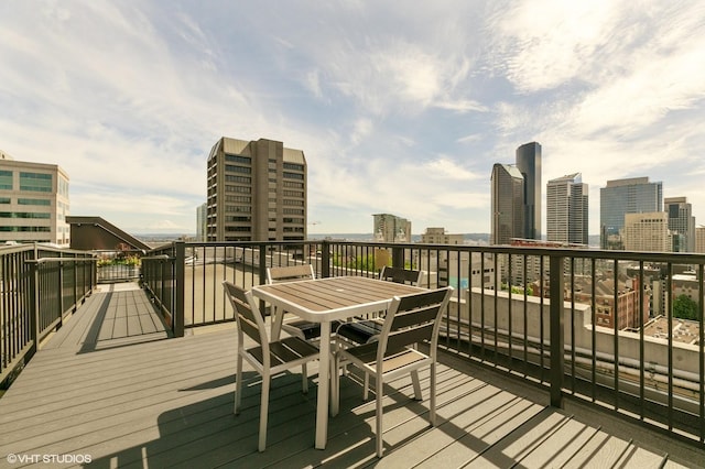 deck featuring a view of city and outdoor dining space