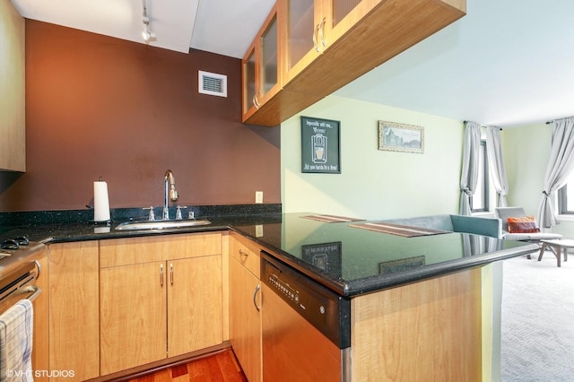kitchen with visible vents, appliances with stainless steel finishes, a sink, dark stone countertops, and a peninsula