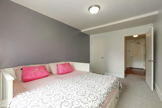 bedroom with baseboards and light carpet