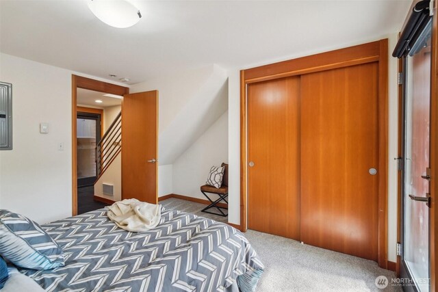 carpeted bedroom with visible vents and a closet