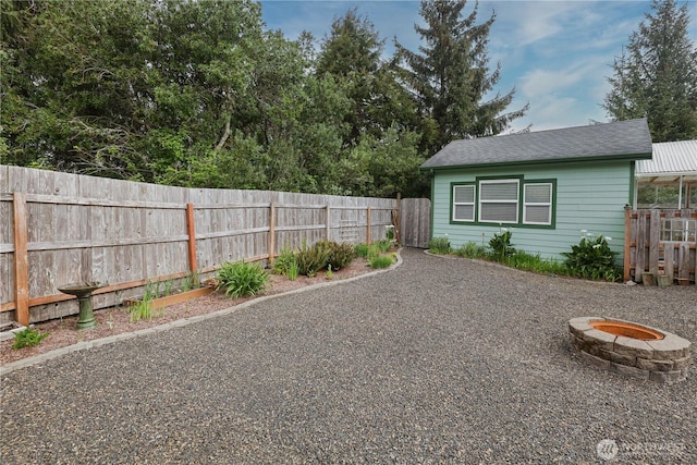 exterior space featuring a fenced backyard and a fire pit