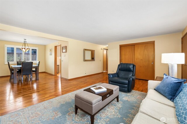 living area with baseboards and wood finished floors