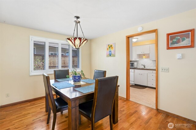 dining room with baseboards and light wood-style flooring