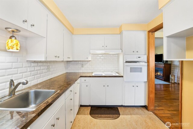 kitchen featuring a sink, white cabinetry, white appliances, and tasteful backsplash