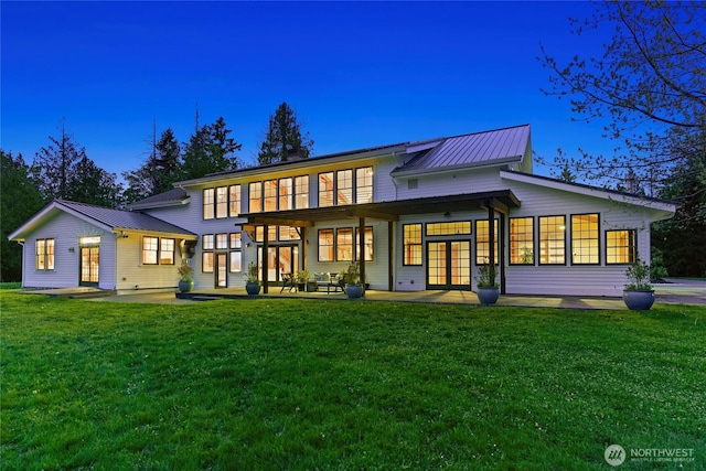 back of house with a lawn, french doors, metal roof, and a patio area