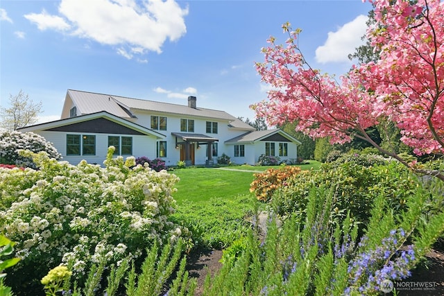 view of front of home featuring a chimney and a front yard