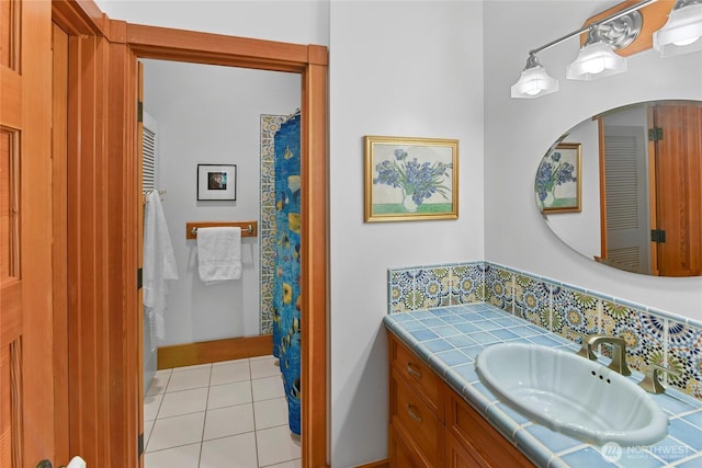 bathroom featuring vanity, tile patterned flooring, baseboards, and backsplash