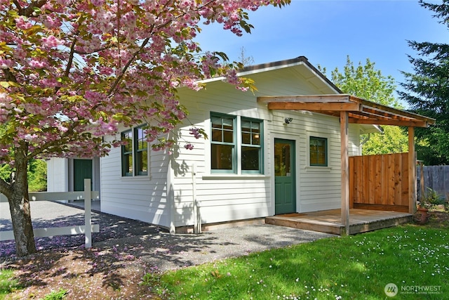 bungalow-style home featuring fence
