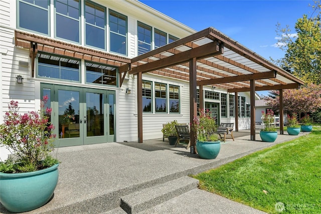 rear view of property featuring a pergola, french doors, and a patio area