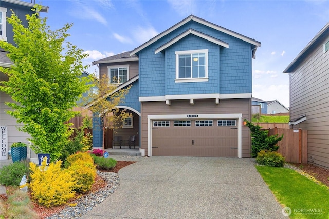 craftsman-style house featuring a garage, fence, and driveway