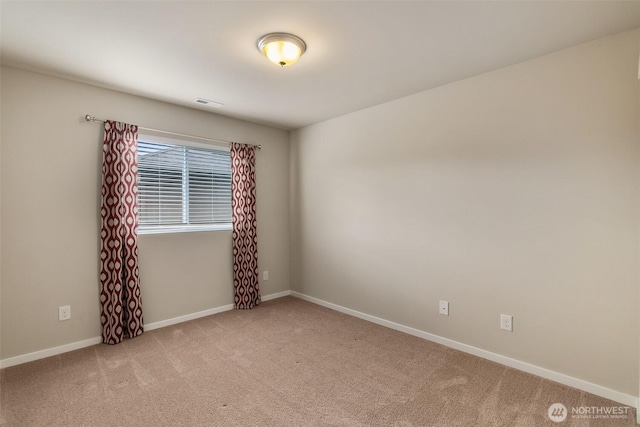 empty room featuring carpet floors, baseboards, and visible vents