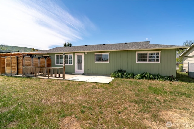 rear view of property featuring a yard, a patio, and fence