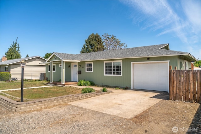 ranch-style house featuring fence, a front yard, roof with shingles, concrete driveway, and an attached garage