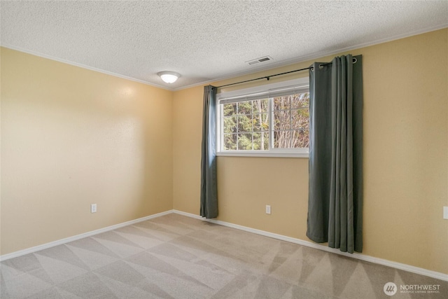 empty room with crown molding, light carpet, a textured ceiling, baseboards, and visible vents