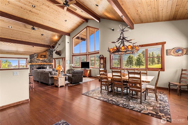 dining room featuring baseboards, dark wood-style flooring, a fireplace, wooden ceiling with exposed beams, and a ceiling fan