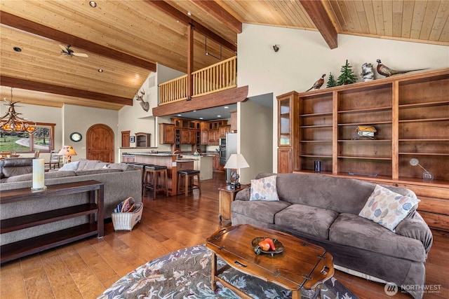 living room featuring wooden ceiling with exposed beams, wood finished floors, high vaulted ceiling, and a chandelier
