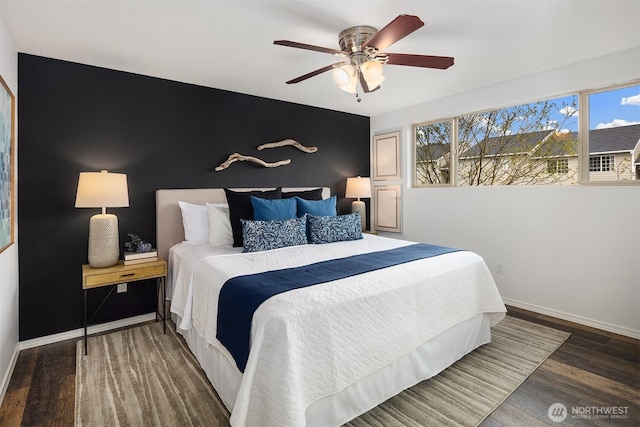 3834 175th Ave NE Unit 209, Redmond, WA 98052 - bedroom featuring baseboards, ceiling fan, an accent wall, and wood finished floors
