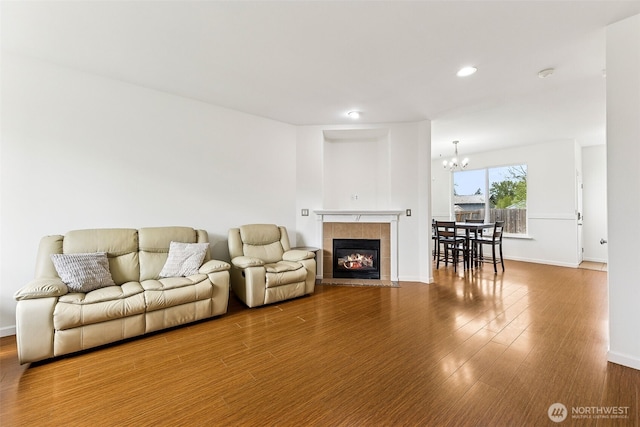 living room featuring recessed lighting, baseboards, a chandelier, and wood finished floors