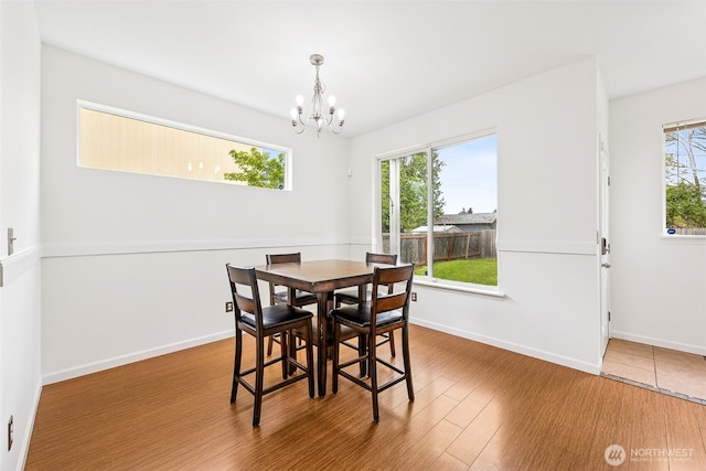 dining area featuring an inviting chandelier, baseboards, and wood finished floors