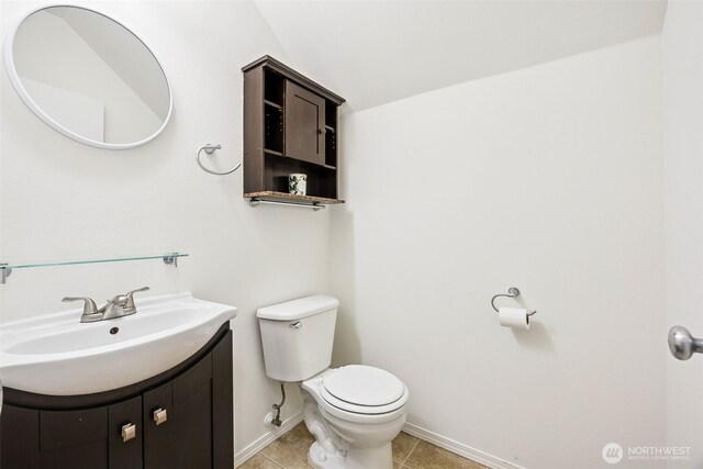 bathroom with baseboards, tile patterned flooring, vanity, and toilet