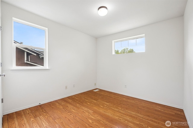 unfurnished room with baseboards and light wood-style flooring
