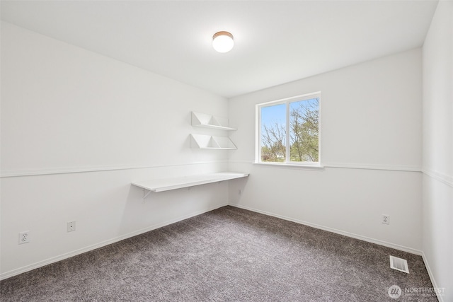 carpeted spare room featuring visible vents and baseboards