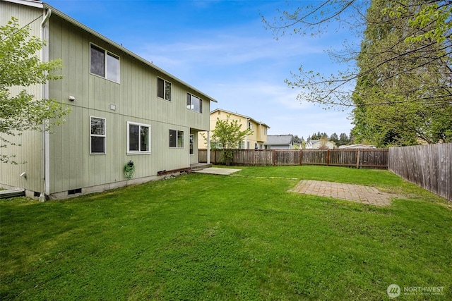 back of property with a fenced backyard, a yard, and a patio area