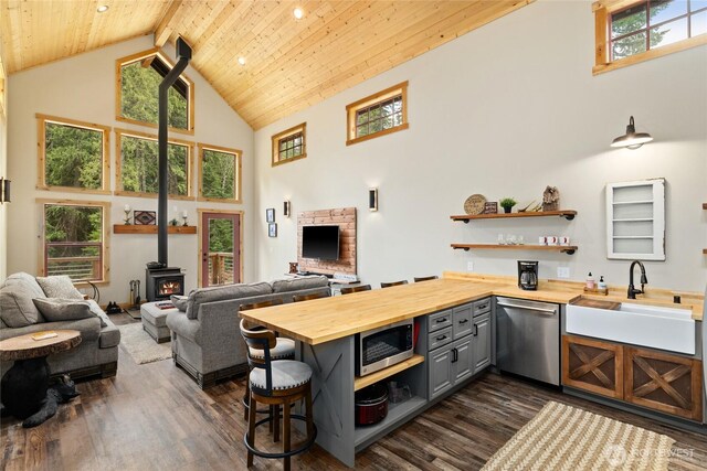 kitchen featuring open shelves, gray cabinets, wooden counters, and stainless steel appliances