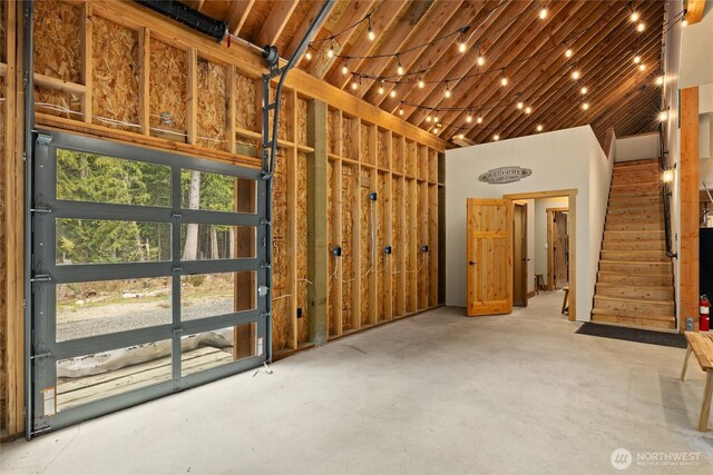 interior space featuring a high ceiling, concrete flooring, and stairs