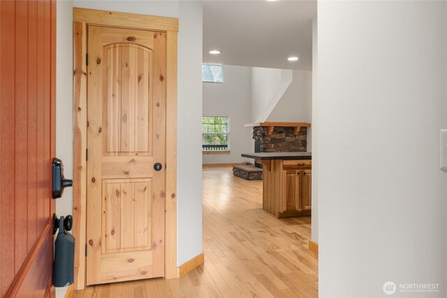 corridor featuring recessed lighting, light wood-style flooring, and baseboards