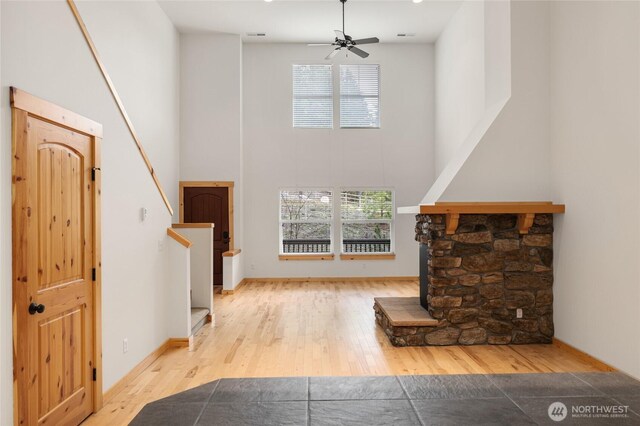 living area featuring a high ceiling, a wealth of natural light, and hardwood / wood-style floors