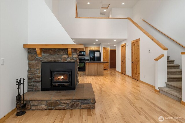 living area with recessed lighting, baseboards, stairs, and light wood-style flooring