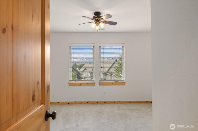 spare room featuring carpet floors, ceiling fan, and baseboards